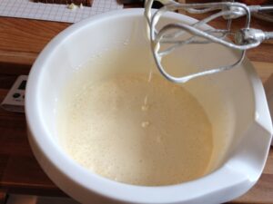 Die Zucker und Eier für Brownies mit Handmixer verrühren