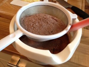 Mehl und Kakao für Brownies durchsieben